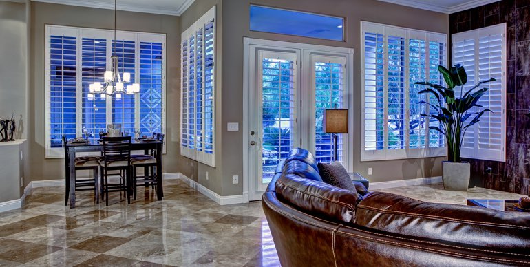 Hartford great room with white shutters and tile floor.